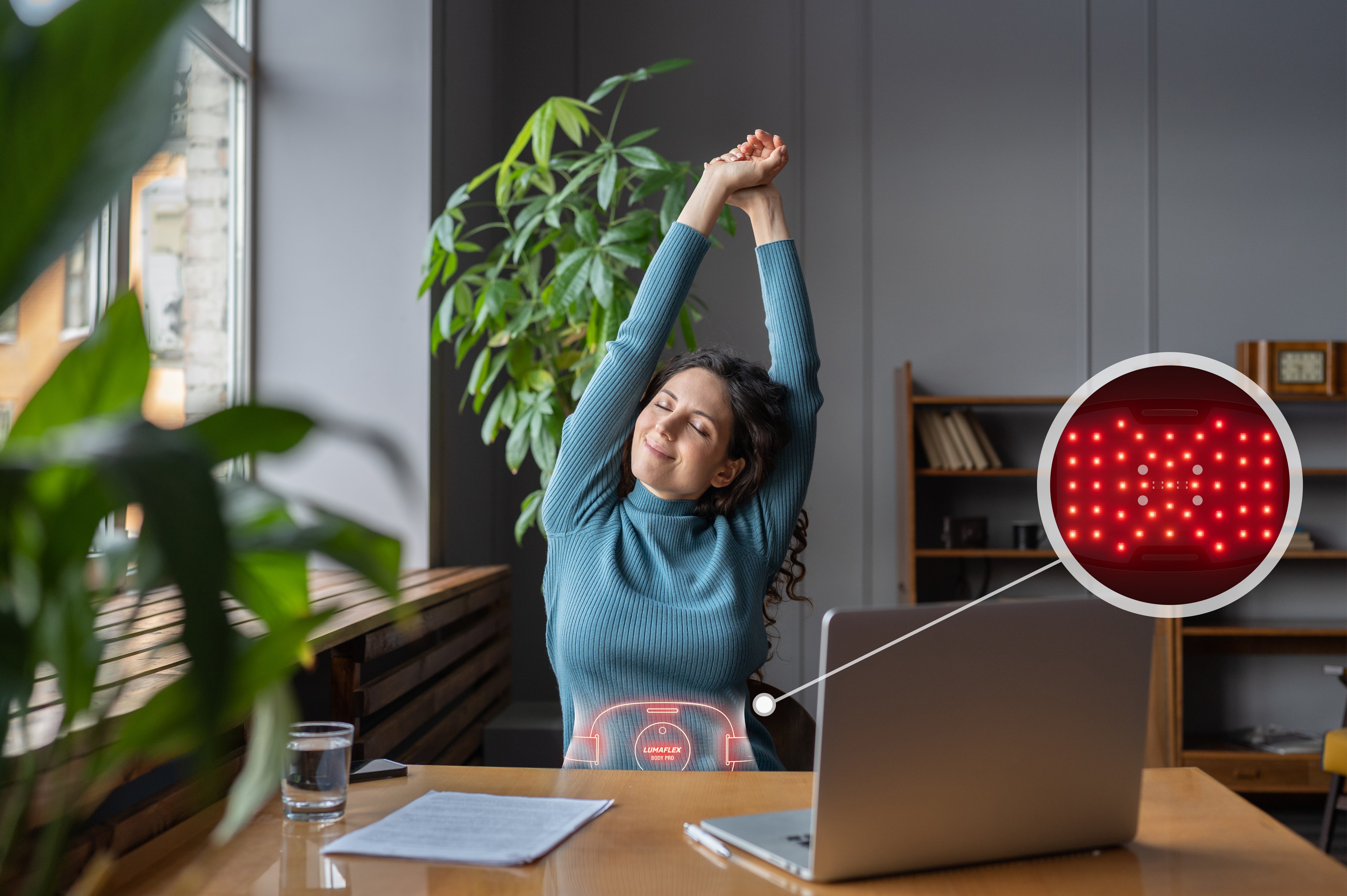 Woman in blue sweater using Lumaflex on her abs.